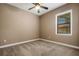 Cozy bedroom with neutral carpet, ceiling fan and a window letting in natural light at 6527 Eagle Ridge Way, Lakeland, FL 33813