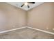 A simply designed bedroom with neutral colored walls, base trim, carpet flooring, and a ceiling fan at 6527 Eagle Ridge Way, Lakeland, FL 33813