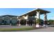 Exterior view of the clubhouse, featuring a covered entrance, brick columns, and lush landscaping at 6527 Eagle Ridge Way, Lakeland, FL 33813
