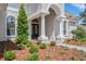 Inviting front entrance with elegant columns, arched entryway, and professionally landscaped flower beds at 6527 Eagle Ridge Way, Lakeland, FL 33813