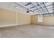 A clean three-car garage with an epoxy floor, overhead lighting, and ample space for storage at 6527 Eagle Ridge Way, Lakeland, FL 33813