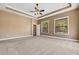 Spacious main bedroom featuring a tray ceiling, a ceiling fan, neutral paint, and two windows for ample natural light at 6527 Eagle Ridge Way, Lakeland, FL 33813