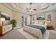 Spacious main bedroom with tray ceilings, a ceiling fan, and access to a private balcony at 6527 Eagle Ridge Way, Lakeland, FL 33813