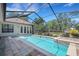 Relaxing screened-in swimming pool and spa with brick pool deck and view of the backyard at 6527 Eagle Ridge Way, Lakeland, FL 33813