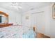 Simple bedroom featuring floral bedding, a ceiling fan, and ample closet space at 7016 Summit Cir, Winter Haven, FL 33884