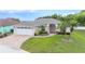 Beautiful single-story home with mature landscaping, a paver driveway, and an attached two-car garage at 7016 Summit Cir, Winter Haven, FL 33884