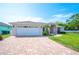 Charming single-story home with a well-manicured lawn, paver driveway, and an attached two-car garage at 7016 Summit Cir, Winter Haven, FL 33884