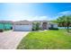 Beautiful home featuring a well-manicured lawn and brick-paved driveway at 7016 Summit Cir, Winter Haven, FL 33884