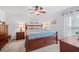 Comfortable primary bedroom with a ceiling fan and plush bedding, accompanied by matching wooden furniture at 7016 Summit Cir, Winter Haven, FL 33884