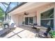 Covered patio with comfortable lounge chairs, outdoor dining set, grill, and access to the pool area at 7016 Summit Cir, Winter Haven, FL 33884