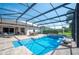 Screened-in pool with brick patio, outdoor seating, and a well-maintained deck with lush landscaping at 7016 Summit Cir, Winter Haven, FL 33884