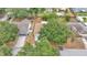 Aerial view of a house with a large tree in the front yard and a fenced backyard at 7311 Briarbay Loop, Lakeland, FL 33810