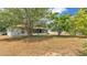 Wide backyard with partial view of the home and mature trees at 7311 Briarbay Loop, Lakeland, FL 33810