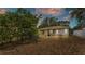 Private backyard featuring mature trees, a screened-in lanai, and a well-maintained lawn at 7311 Briarbay Loop, Lakeland, FL 33810