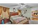 Bedroom with ceiling fan, curtains, a painting on the wall, and doorway at 7311 Briarbay Loop, Lakeland, FL 33810