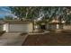 Charming single-story home with a two-car garage, well-maintained lawn, and mature shade trees at 7311 Briarbay Loop, Lakeland, FL 33810
