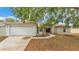 Charming single-story home with a two-car garage, well-maintained lawn, and mature shade trees at 7311 Briarbay Loop, Lakeland, FL 33810