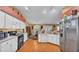 Well-lit kitchen with white cabinetry, stainless steel refrigerator, and wood-look flooring at 7311 Briarbay Loop, Lakeland, FL 33810