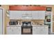 Well-maintained kitchen features white cabinets, black appliances and a view of the other living spaces at 7311 Briarbay Loop, Lakeland, FL 33810
