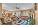 Open-concept living room with ceiling fan, view of the dining area and double doors leading to outdoor space at 7311 Briarbay Loop, Lakeland, FL 33810