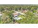 An aerial view shows the home with a pool, storage shed, and large trees at 808 Austin Cir, Bartow, FL 33830