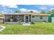 Backyard view of the home with a screened-in patio and well-maintained lawn at 808 Austin Cir, Bartow, FL 33830