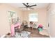 Bedroom featuring vanity desk, wood floors, ceiling fan, and two windows at 5732 Sawyer Rd, Lakeland, FL 33810