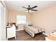 Cozy bedroom with wood floors, ceiling fan, and a window letting in natural light at 5732 Sawyer Rd, Lakeland, FL 33810