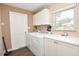 Functional laundry room featuring a washer, dryer, storage cabinets, and a window at 5732 Sawyer Rd, Lakeland, FL 33810