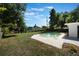 Backyard featuring a swimming pool, trees and a grassy area with blue skies at 3813 Surrey Dr, Orlando, FL 32812