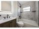 This bathroom features a tub, shower, marble tile, a window and modern sink at 3813 Surrey Dr, Orlando, FL 32812