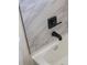 Bathroom features a tub with marble-style tiles and black hardware at 3813 Surrey Dr, Orlando, FL 32812