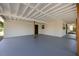 A spacious carport features a painted concrete floor, wooden support beams, and a whitewashed ceiling and walls at 3813 Surrey Dr, Orlando, FL 32812