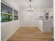 Bright dining area with wood floors, a modern chandelier, and a large window offering scenic views at 3813 Surrey Dr, Orlando, FL 32812