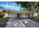This home features a spacious carport, a modern paint scheme, and is complemented by lush surrounding greenery at 3813 Surrey Dr, Orlando, FL 32812