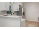 Bright kitchen with modern white cabinets, quartz counters, stainless steel appliances, and wood floors at 3813 Surrey Dr, Orlando, FL 32812
