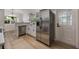 Bright kitchen featuring stainless steel appliances, light wood floors, white cabinets and modern countertops at 3813 Surrey Dr, Orlando, FL 32812