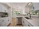 Bright kitchen featuring stainless steel appliances, white cabinets, and a view to the front yard at 3813 Surrey Dr, Orlando, FL 32812