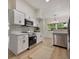 Bright kitchen featuring stainless steel appliances, white cabinets, and modern countertops at 3813 Surrey Dr, Orlando, FL 32812