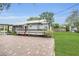 Charming home with a brick driveway, wooden deck, and a well-maintained lawn at 1013 Pennsylvania Ave, Lakeland, FL 33803