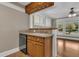 Compact kitchen area featuring wood cabinets and a sink, open to a bright living space with windows at 1013 Pennsylvania Ave, Lakeland, FL 33803