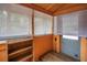 Enclosed porch with shelving and windows, offering a cozy and versatile space at 1013 Pennsylvania Ave, Lakeland, FL 33803