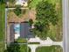 Aerial view of a backyard oasis with a pool, privacy fence, mature trees, well maintained landscaping, and a view of the street at 1130 Ewell Rd, Lakeland, FL 33811