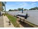 Backyard area with a walkway, some grass, and a built-in black grill at 1130 Ewell Rd, Lakeland, FL 33811