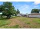 Large backyard with healthy lawn, mature shade trees, and a partial view of pool area at 1130 Ewell Rd, Lakeland, FL 33811