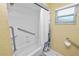 Bright bathroom featuring a shower/tub combo with safety bars and a convenient window at 1130 Ewell Rd, Lakeland, FL 33811
