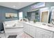 Bathroom features a jacuzzi tub, double vanity, a large mirror, and blue walls at 1130 Ewell Rd, Lakeland, FL 33811