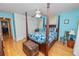 Bedroom with blue walls, a four-poster bed, hardwood floors and bright, natural light at 1130 Ewell Rd, Lakeland, FL 33811