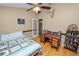 Bedroom with an ensuite bathroom, desk, hardwood floors, a bookshelf, and a ceiling fan at 1130 Ewell Rd, Lakeland, FL 33811
