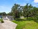 View of a well-kept yard with mature trees, landscaping, a large driveway, and a charming single-story home at 1130 Ewell Rd, Lakeland, FL 33811